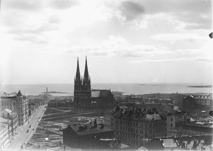 Kuvan keskellä on Johanneksen kirkko, etualalla rakennuksia, vasemmalla Korkeavuorenkatu ja taustalla meri. Suurin osa rakennuksista on matalia puutaloja. 