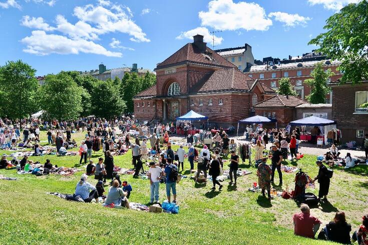 Paikalle on saapunut kirpputorikansaa sankoin joukoin. Takana entinen Harjun nuorisotalo, joka on valmistunut vuonna 1923, alun perin ruumishuoneeksi, mutta 1986–2019 se toimi nuoriso­talona. Nuorisotalon toiminta päättyi vuonna 2019 sisäilmaongelmien vuoksi. Dallapénpuisto on nimetty kuuluisan 1920 perustetun yhtyeen mukaan.