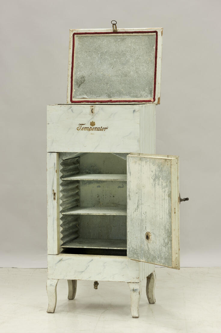 Matalien kaarevien jalkojen varassa seisova korkea, suoraseinäinen kaappi, jonka yläosassa jääarkku, alaosa säilytystila. Sisvuseinät paneloitu, peiliovi. Ovessa salpa ja lukko. Sisäpuoli vuorattu pellillä. Kaksi lasihyllyä ja alimpana hyllynä metallilevy. Pohjassa sulkuhana. Takaseinässä ja ovessa pyöreä venttiili. Tehtaan merkki: TEMPERATOR, Patent loistovaakuna kilvenkantajineen. Kaappi maalattu vaaleanharmaaksi, väri todennäköisesti alkuperäinen.