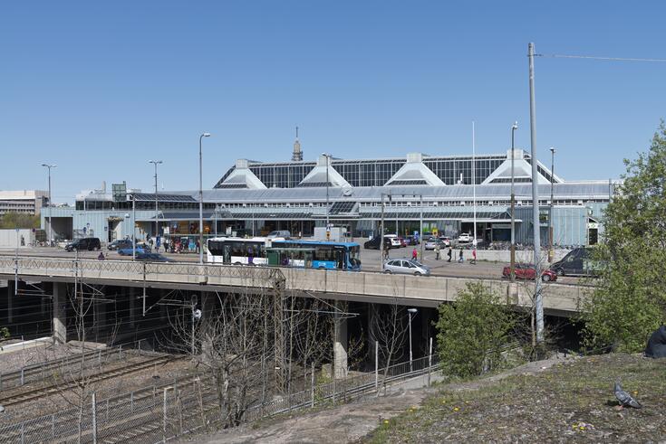 Böles station som blev färdig år 1990 fotograferad från Bangårdsvägen. Byggnaden är i blågråa toner och står upphöjd från rälsarna på pelare. Den har trekantiga takkonstruktioner. 