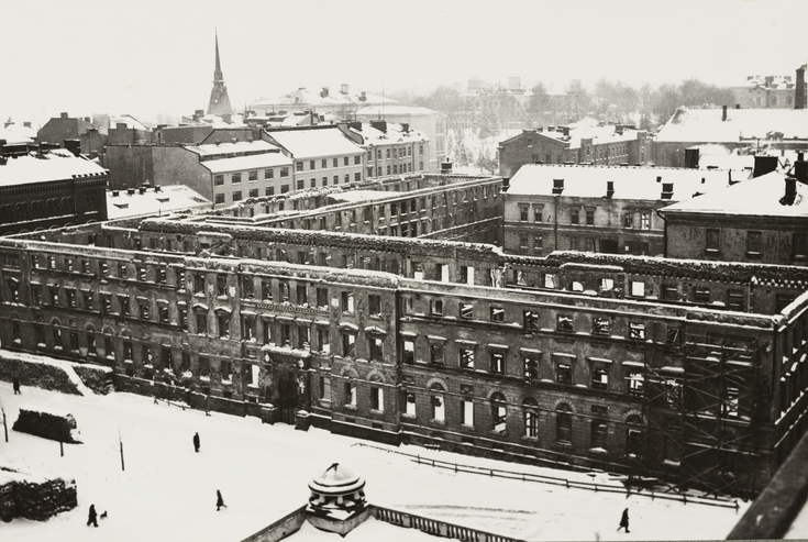 Gardeskasernen uppifrån sedd.  Byggnadens ytterväggar stor kvar, men taket och konstruktionerna inuti är helt förstörda.