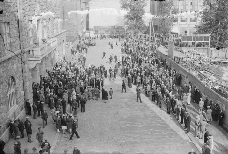 Kommunistit ovat kokoontuneet mielenosoitukseen kadulle Helsingin työväentalon edustalle Siltasaaressa. Kadulla on muutama sata ihmistä.