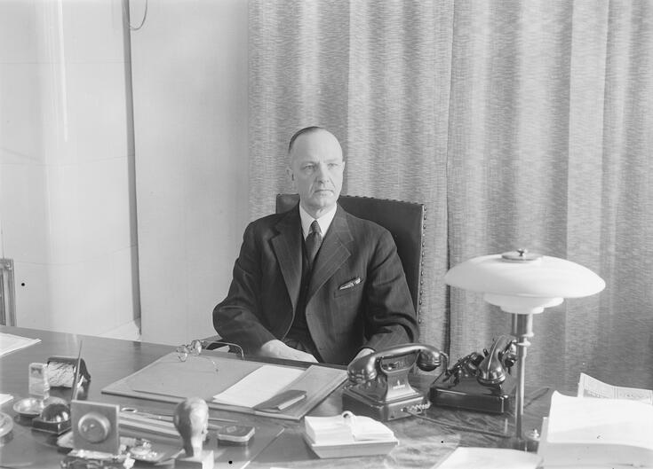 Eero Rydman istumassa työpöytänsä ääressä.