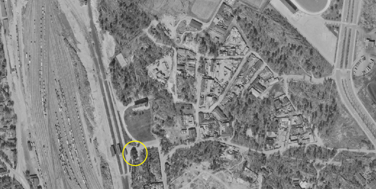 Flygbild rakt uppifrån från Östra Böles område år 1969. På området finns rikligt med träd, byggnaderna är bara små lager- och industrilokaler i trä. 
