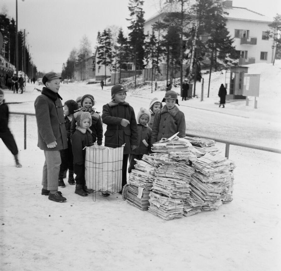 Koululaiset paperinkeräyspinojen kanssa Herttoniemessä Eränkävijäntorilla talvella 1957