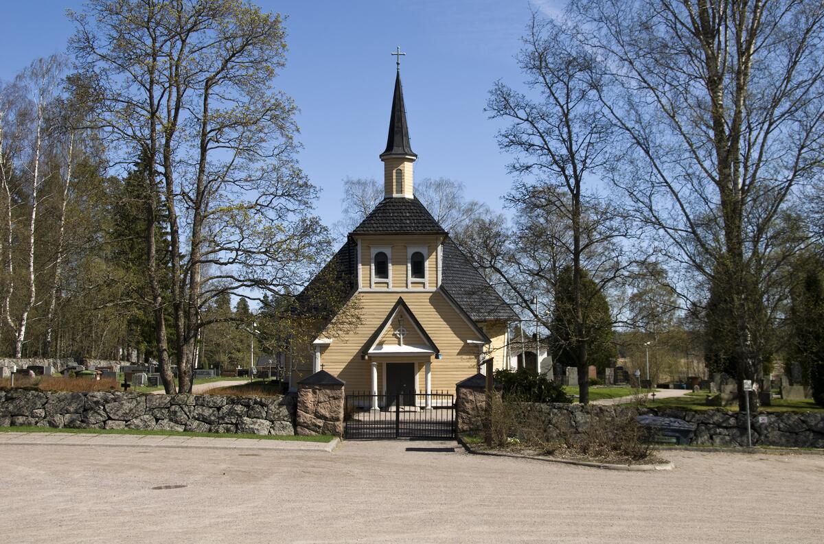 Kirkkorakennus, jnka ympärillä on hautausmaa ja kiviaita