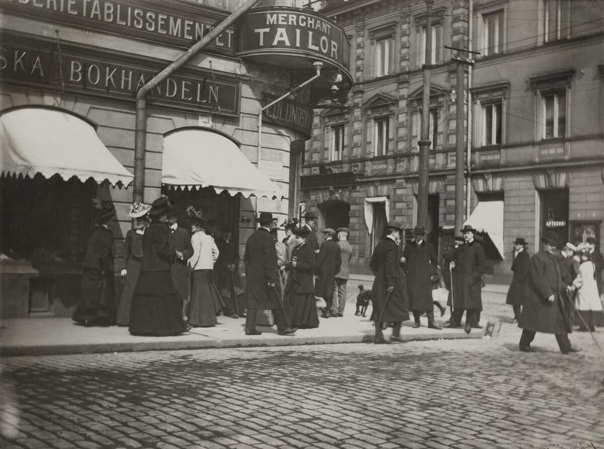 Helsingin katukuva oli kielellisesti moninainen jo vuonna 1908. Kielet voivat kertoa yrittäjien taustasta, mutta niitä on myös käytetty luomaan vaikutelmaa erikoisuudesta tai laadusta. Kuvaaja: Helsingin kaupunginmuseo