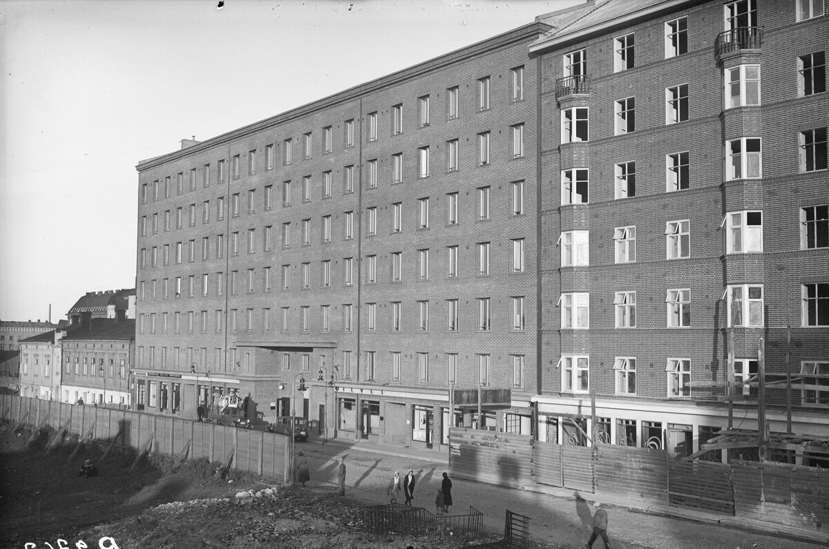 Ett splitternytt sjuvåningshus av tegel fotograferat från framsidan