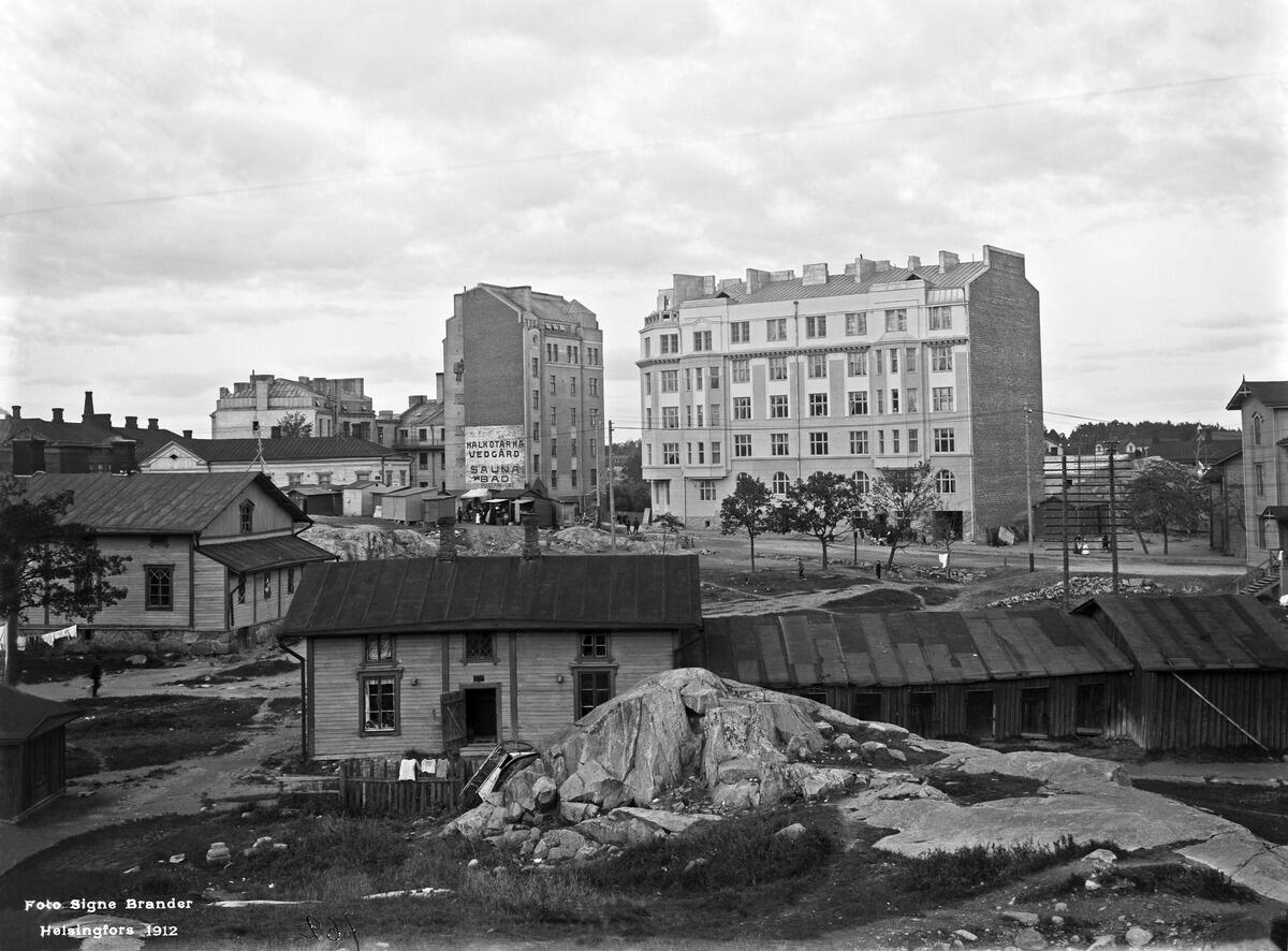 Etualalla Helsinginkatu 4. Takana matala vaalea kivitalo ja korkea kivitalo pääty kuvaan pain on Vaasankatu 5 - Pengerkatu 30 (= Kinaporinkatu 2). Kivitalo oikealla Vaasankatu 3 (= Vaasanpolku 3) - Pengerkatu 31 (= Kinaporinkatu 1).