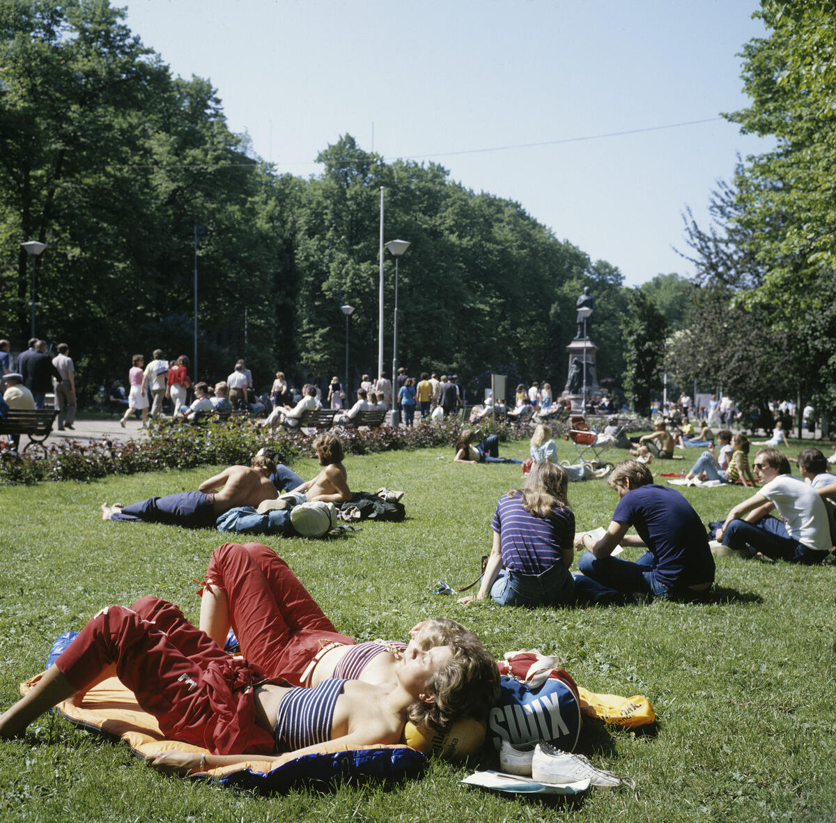 Ungdomar solar sig på Esplanadparkens gräsmatta