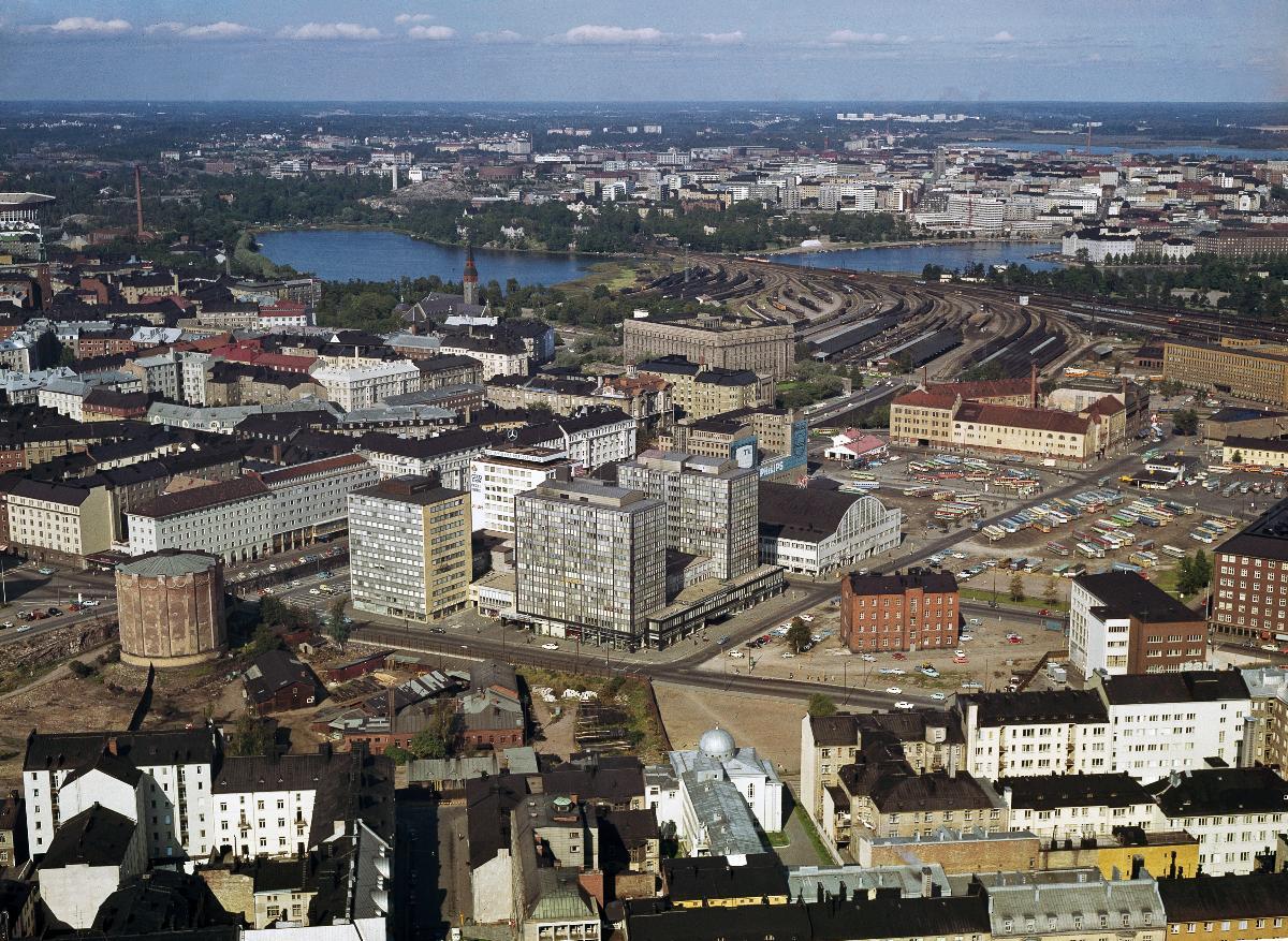 Kampen, i mitten Bilhuset och Tennispalatset. Till vänster Kampens gasklocka som byggdes 1907, och revs 1968. Framför Bilhuset en kasern som revs ungefär samtidigt. Parkeringsplatsen för bussar är i dag Kampens centrum. Bakom fältet ligger Jordbrukarnas mjölkcentrals byggnad.