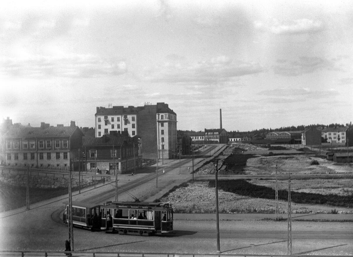 Läntinen Brahenkatu 2b, 6 - Josafatinkatu 5, 7.Oikealla Kallion urheilukenttä. Raitiovaunu kääntymässä Helsinginkadulle.