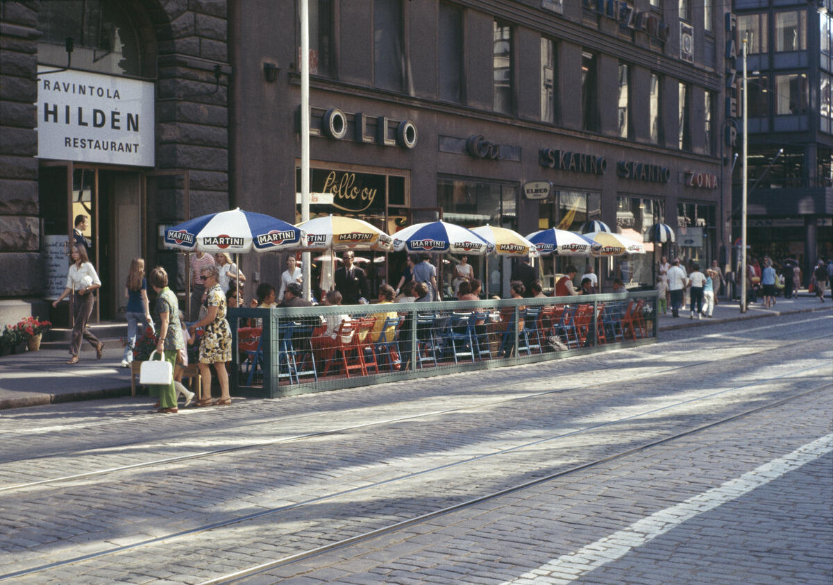 Hildenin katukahvilassa istuskelijoita Aleksanterinkatu 36 b edessä Kävely-Aleksilla. 