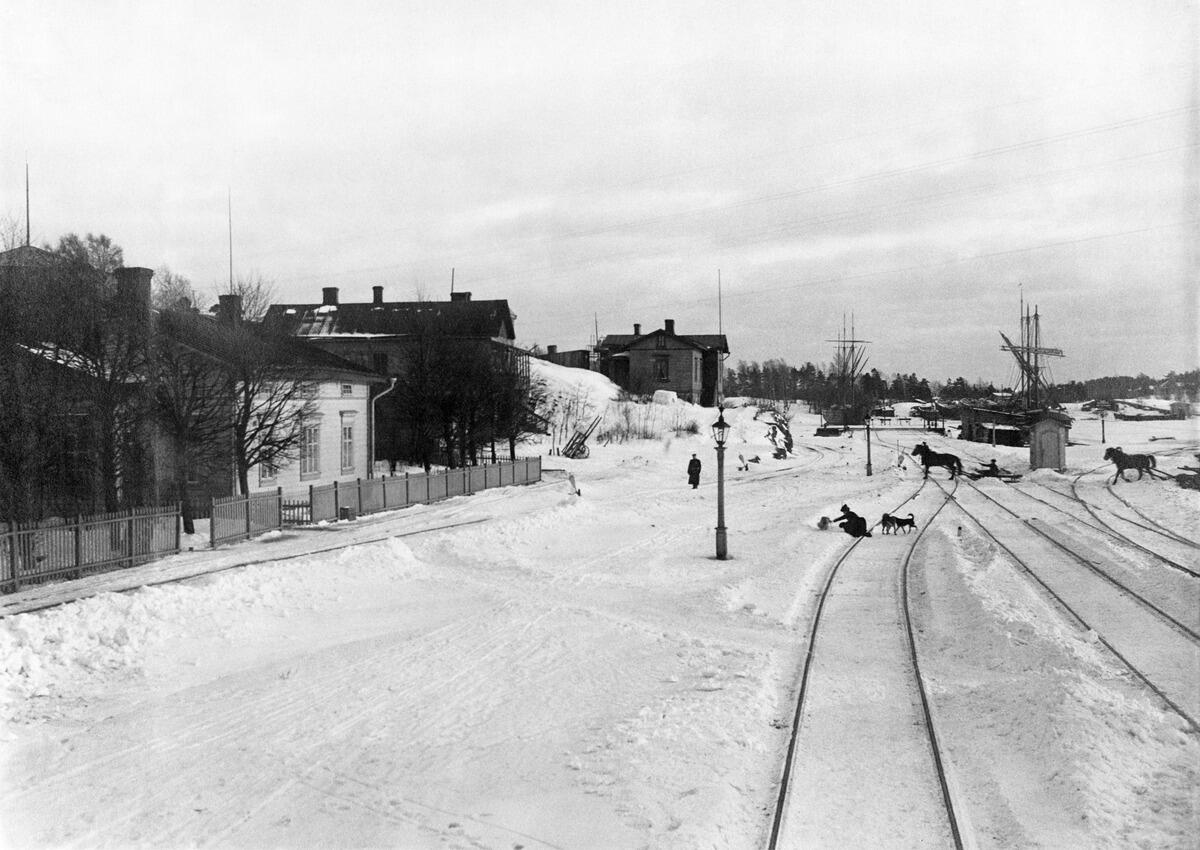 Sörnäs hamnbana och godsstation, Villa Ostkap och tullhuset. I bakgrunden skymtar Blåbärslandet.  Det är snö på marken.