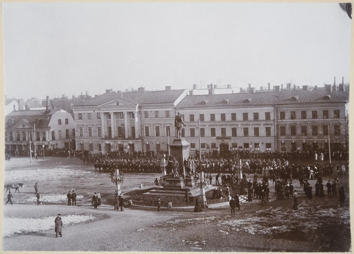 Demonstration against the conscription law, i.e. the so-called Cossack Riots on the Senate Square in April 1902. The conscription law abolished Finland's own army and obliged Finns to participate in the defence of their motherland, Russia. People demonstrating against the law and military conscription began throwing stones, ice cubes, and bottles at the Cossacks who attempted to maintain order, resulting in a violent confrontation. In the picture, the Cossacks are lined up in the background with their horses, the demonstrators in the foreground.  Photo: The Finnish Heritage Agency / Emil Rundman