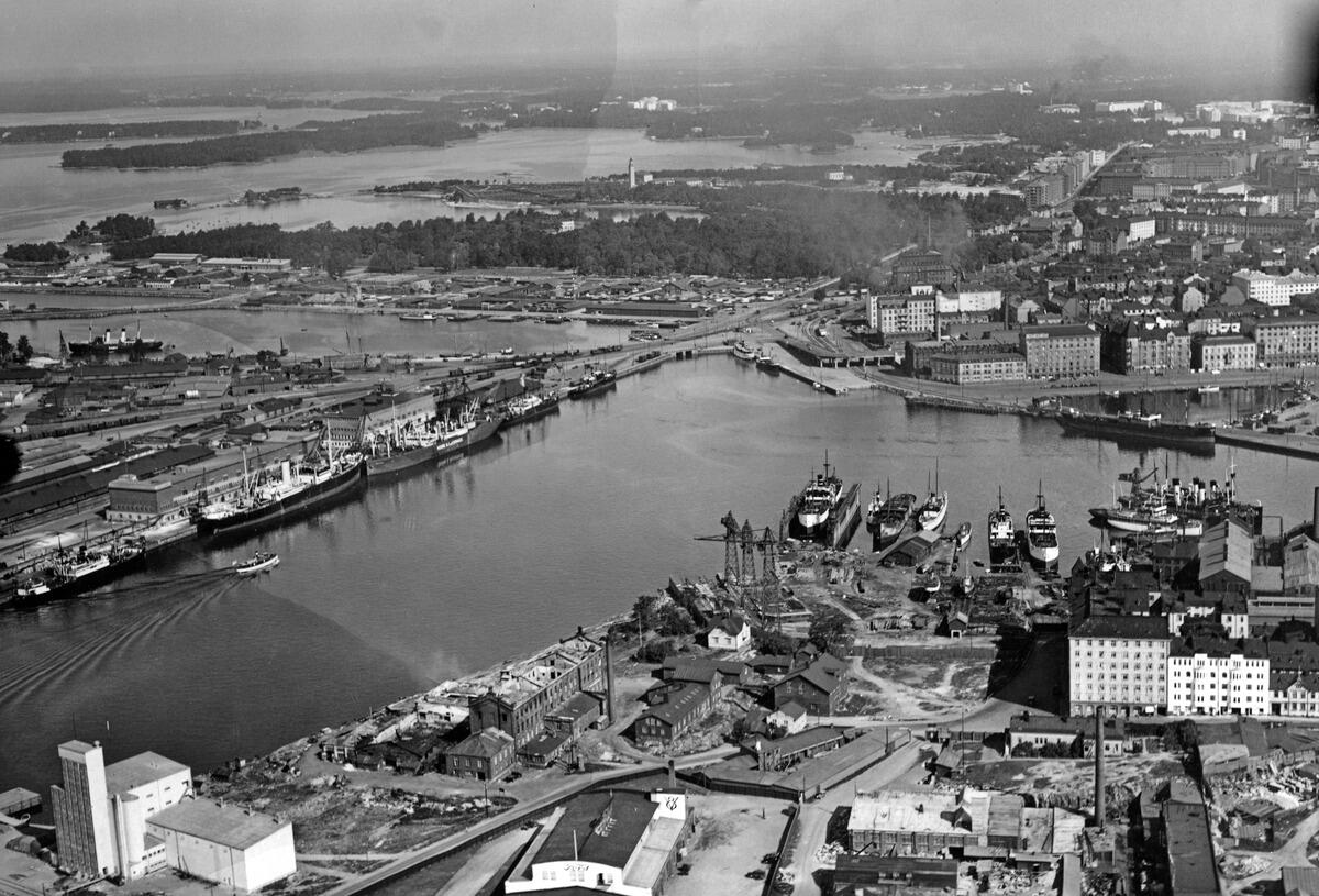 Flygfoto över Västra hamnen från Munkholmen mot Sandviken. I förgrunden till höger Munkholmen. I bakgrunden till vänster Skatudden och Skatuddskajen, till höger Sandviksstranden och Sandviksbassängen. I bakgrunden till höger Kampen.