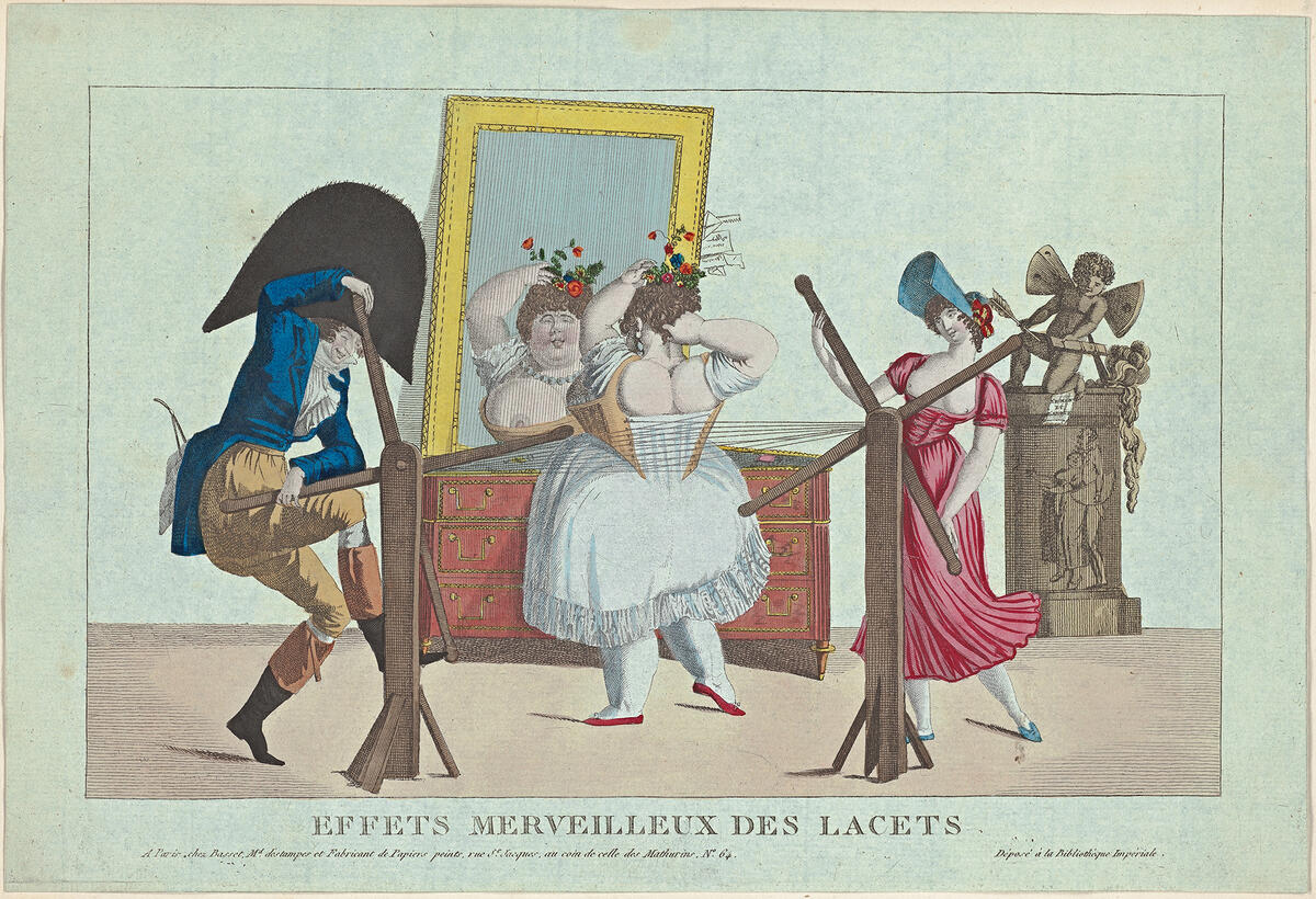 Kuvan keskellä on lihava naurava nainen, jonka korsetin nyörejä kiristävät vasemmalla seisova mies ja oikealla seisova nainen mekaanisen apuvälineen kanssa.