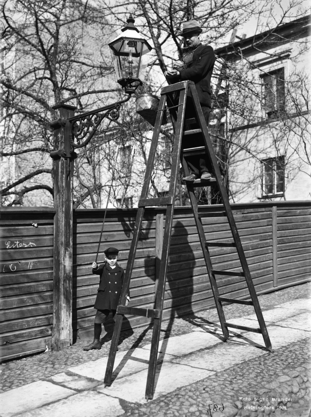 Rengöring av gaslykta på Sjötullsgatan 1912. Foto: Helsingfors stadsmuseum / Signe Brander