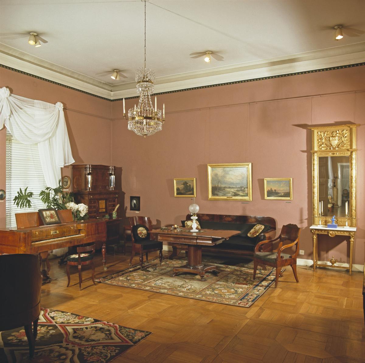 Klaffipiironki ja biedermeier-kalusto huoneessa, jossa on vaaleanpunainen tapetti