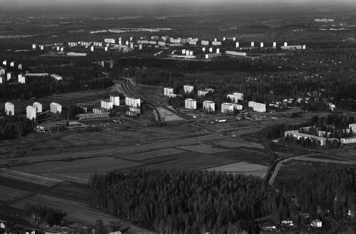 Puotinharjua ja Marjaniemeä ilmakuvassa vuonna 1970. Etualalla Marjaniemen metsää. Keskellä laaja peltoalue, jonka läpi kulkee Itäväylä. Itäväylän pohjoispuolella Puotinharjun matala ostoskeskus ja väljästi sijoitettuja asuinkerrostaloja.