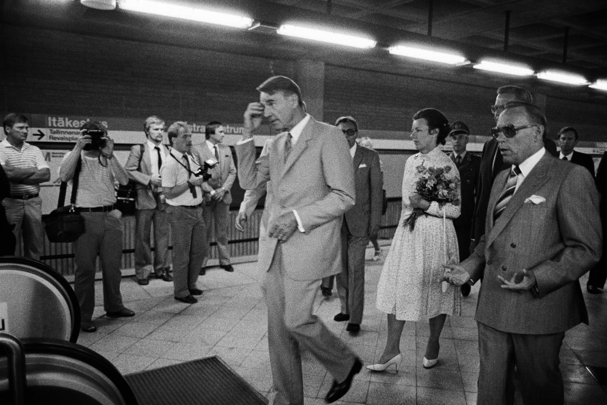 Republikens president Mauno Koivisto med hustru Tellervo bärande en  blombukett i handen, samt metrochefen Unto Valtanen vid metrons öppningsceremoni.  I bakgrunden reportrar som fotograferar.