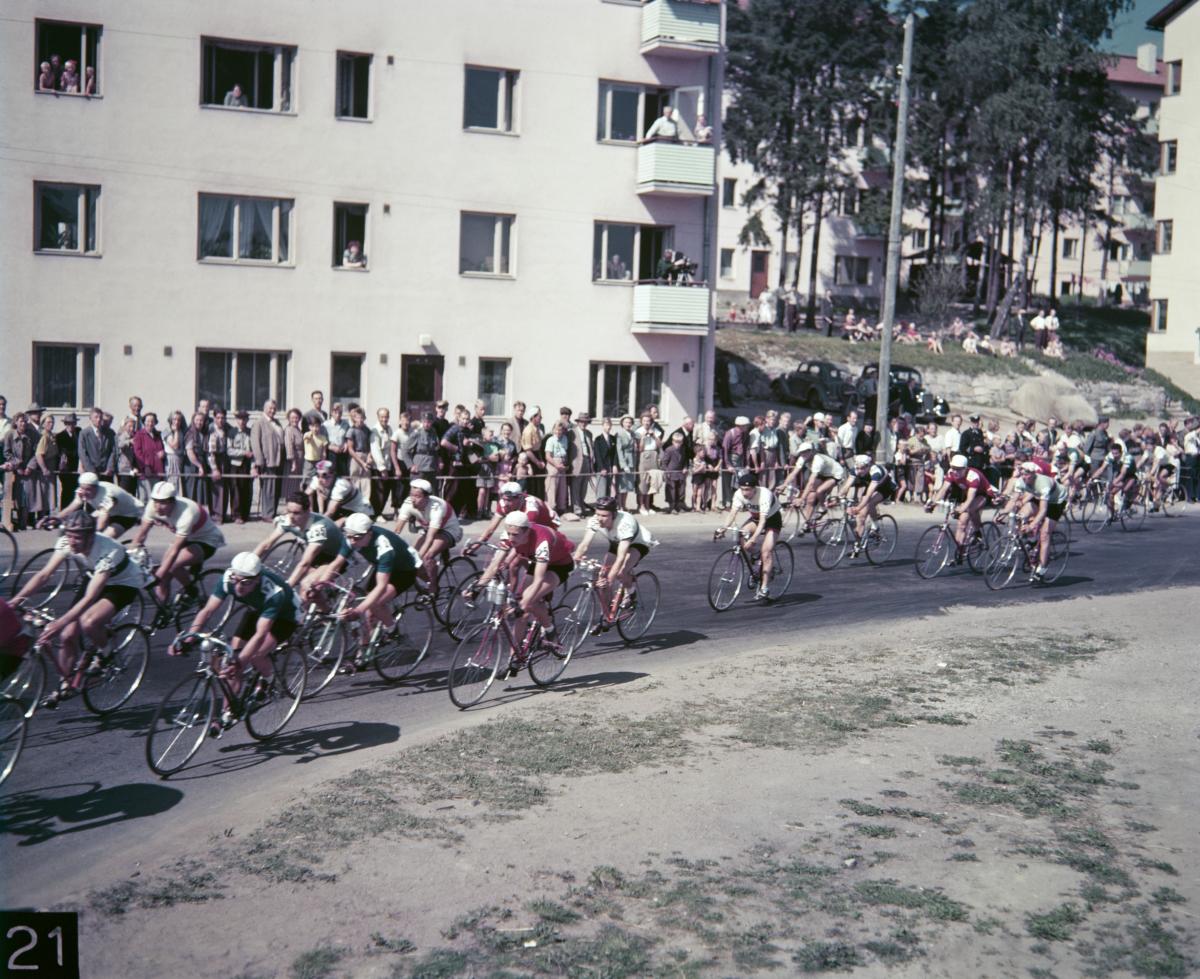 A long line of cyclists riding on a curve 