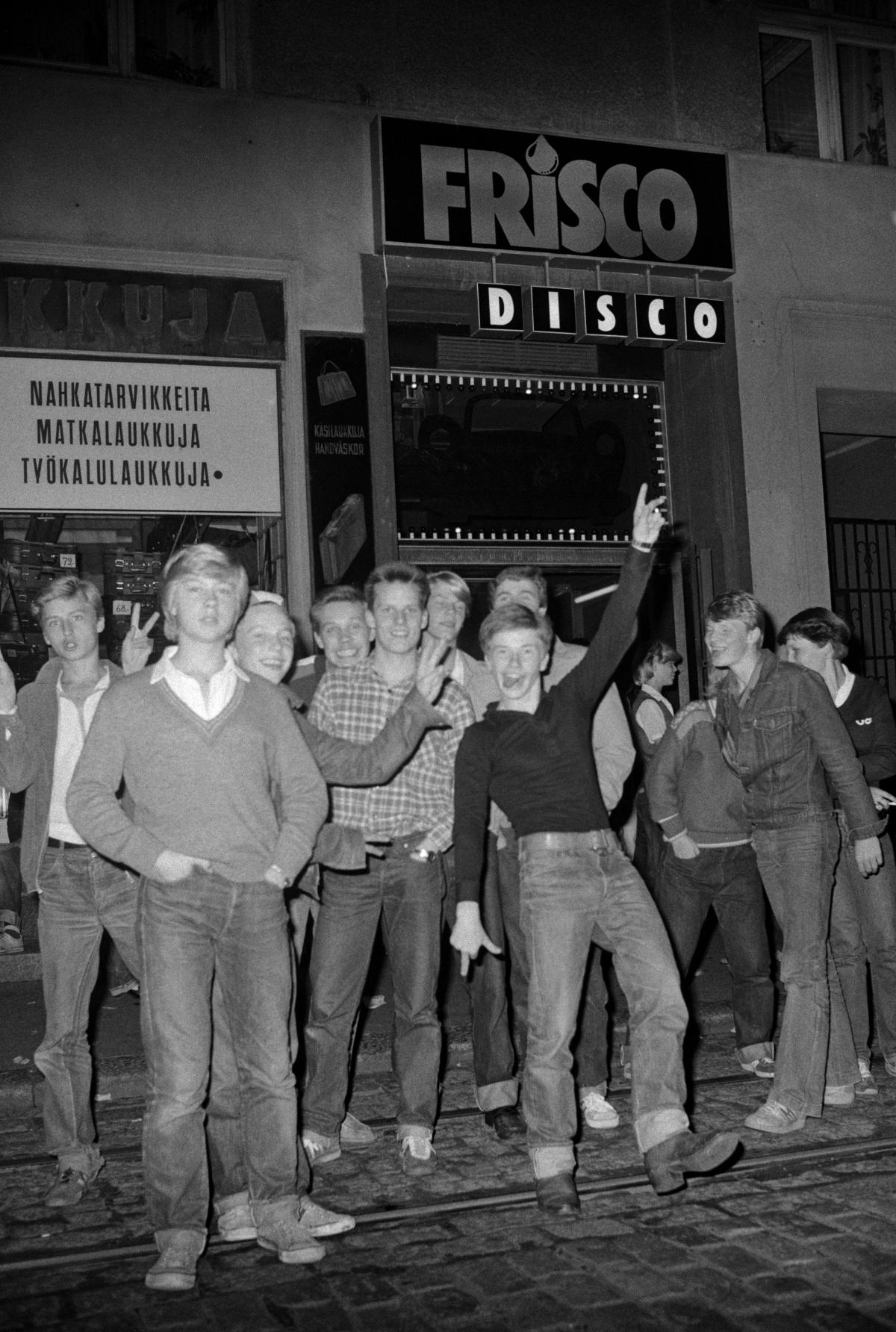En skara ungdomar poserar för fotografen utanför dansrestaurang Frisco Disco år 1978. Alla är klädda i jeans, en del i femtitalsstil.