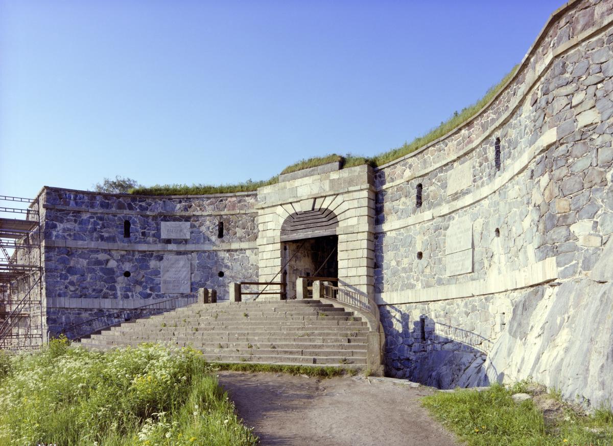 Fotografiet visar en sektorformig öppen plats med trappor som leder till en port som kan stängas med en vindbrygga.