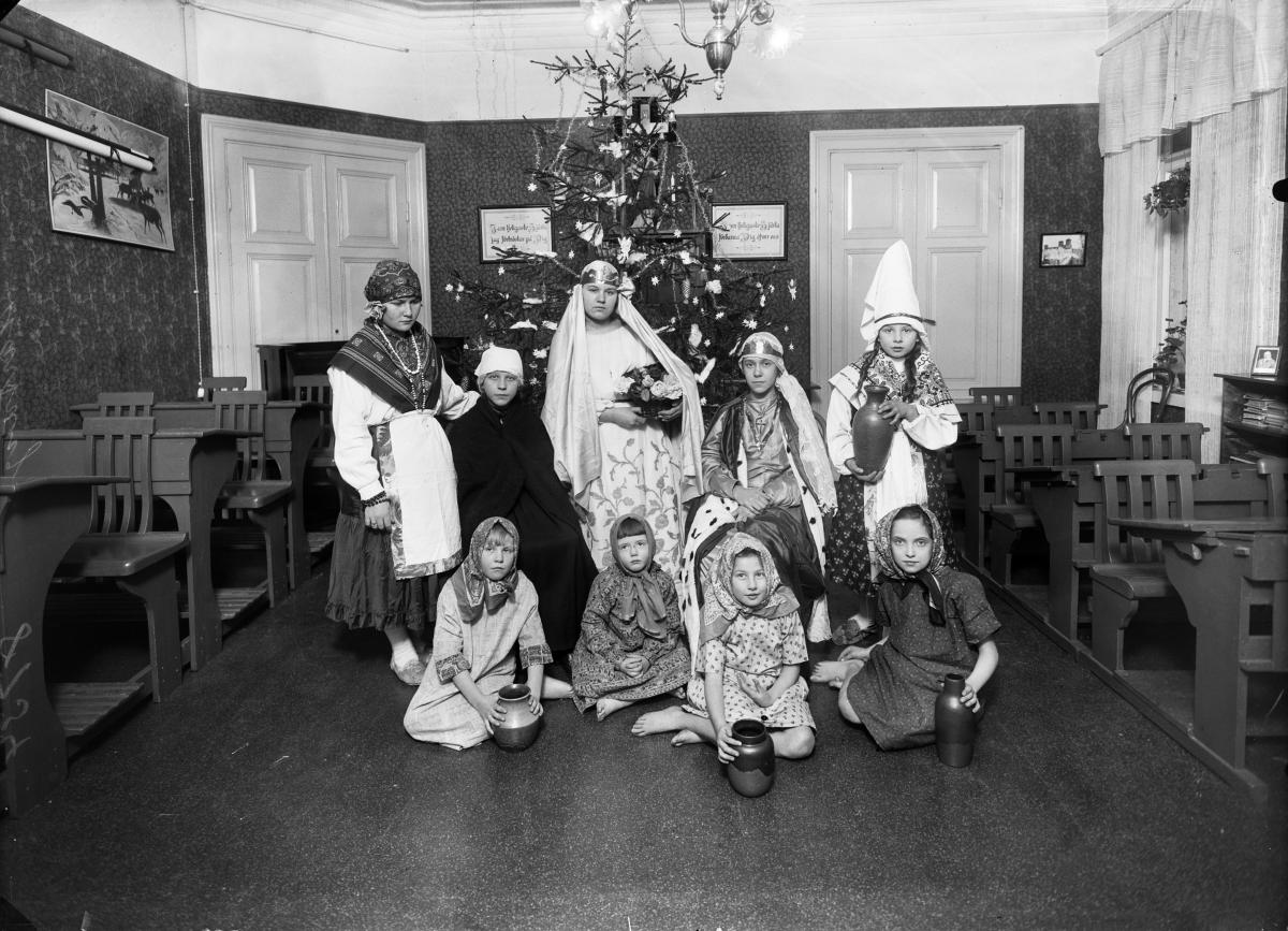 Joulukuusesta tuli jo sata vuotta sitten myös koulujen koriste. Luokassa ollaan itämaisissa vaatteissa jouluevankeliumiesitystä varten vuonna 1928. Eric Sundström/HKM/Finna.