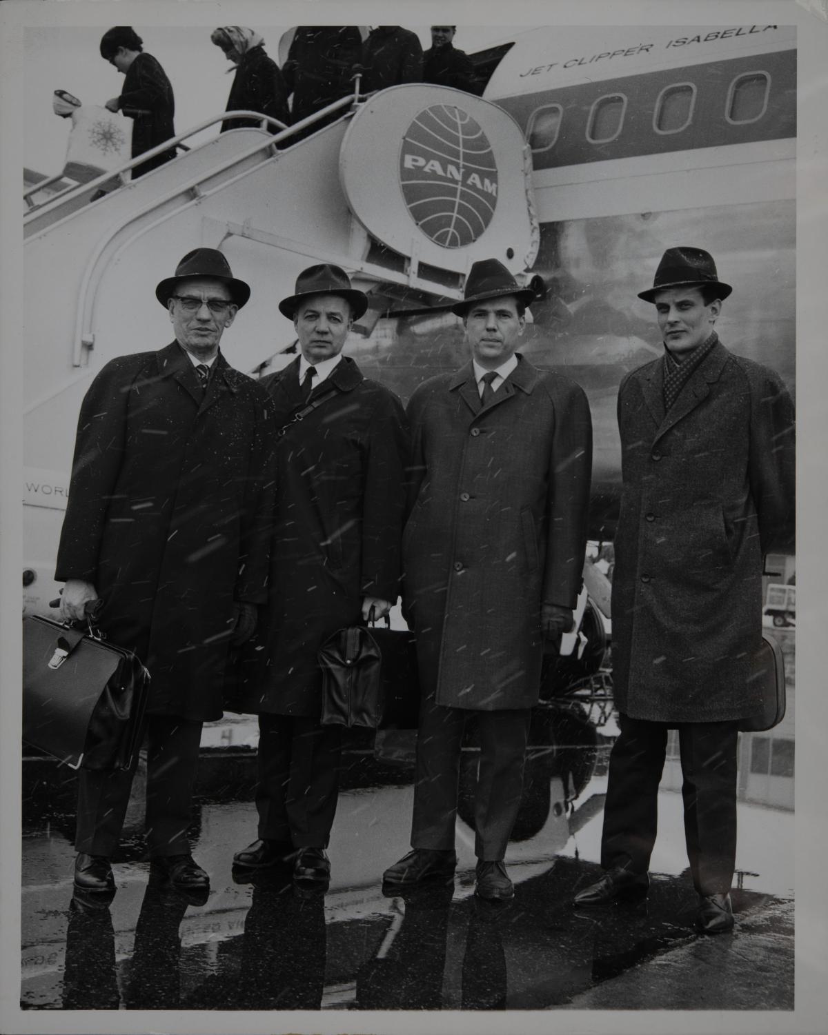 Neljä miestä poseeraa Pan Am -yhtiön lentokoneen edessä.