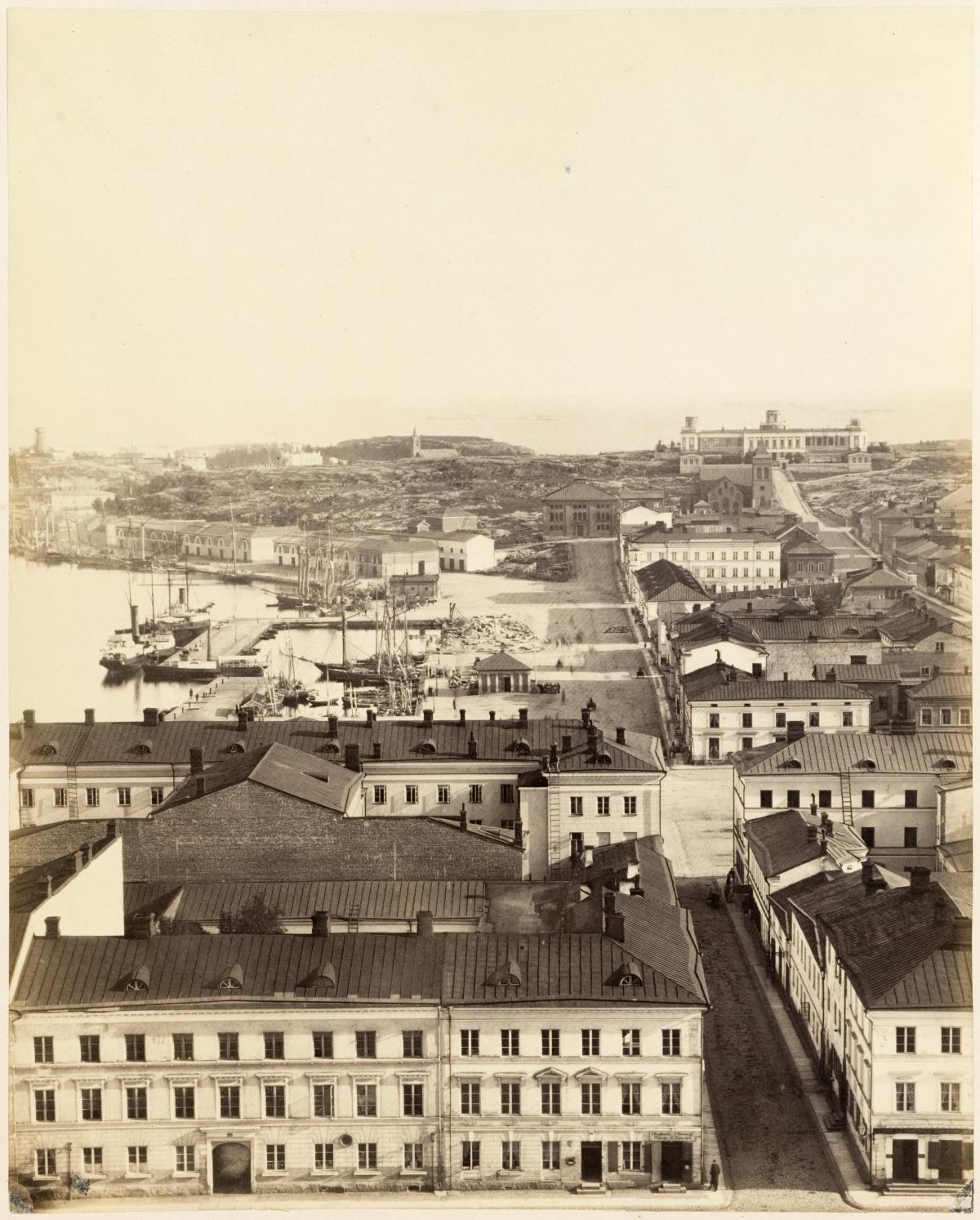 Vanha mustavalkoinen kuva jossa näkyy Helsinkiä 1800-luvun lopun asussa. Etualalla Senaatintori