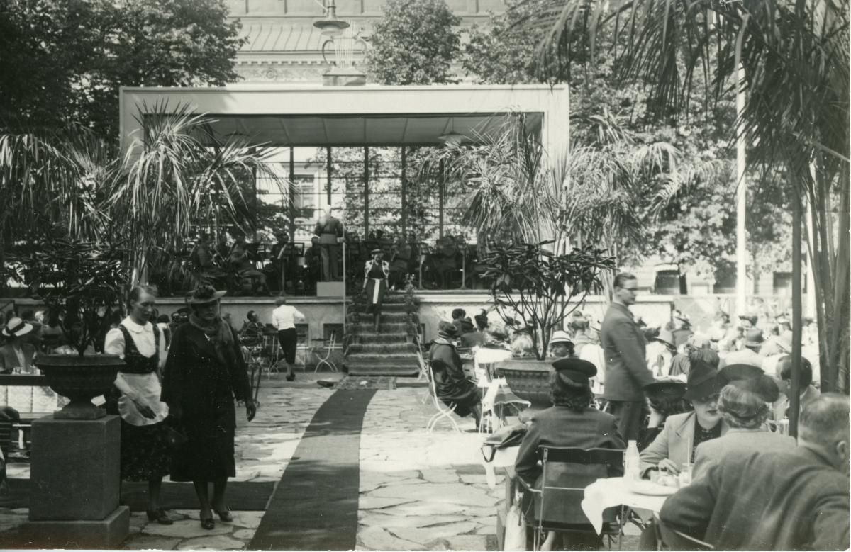 : Esplanadestraden, i förgrunden syns kunder på Esplanadens utekafé, till vänster en servitör. På bilden har estraden redan förnyats (förnyades år 1939).