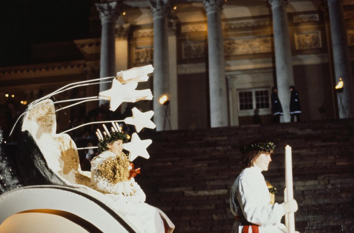 Lucia-kulkue 1980-luvulla. Lucia istuu vaunuissa päässään tunnuksensa kynttiläkruunu. Kuvaaja: Helsingin kaupunginmuseo