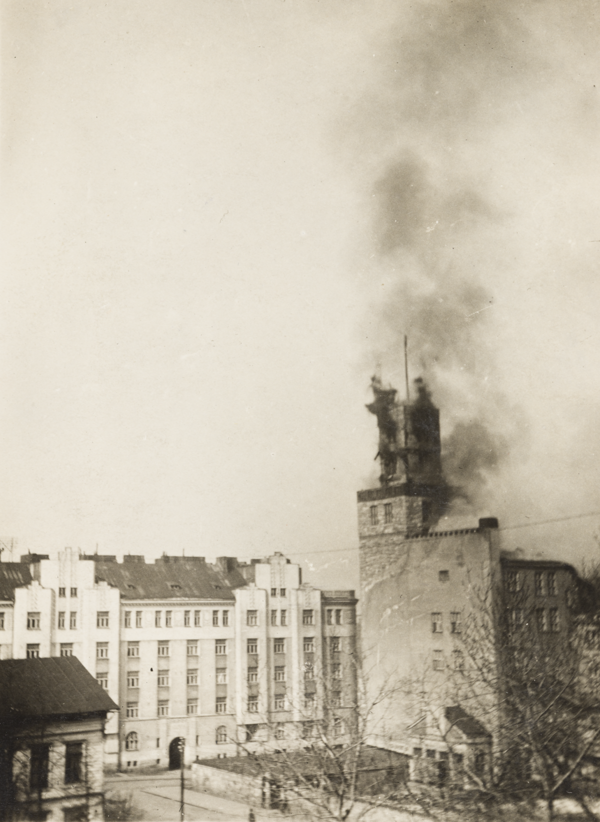 Kuva Hakaniemen työväentalon tornista Helsingin valtauksen aikana 13.4.1918. Torniin on osunut pommi ja siitä nousee mustaa savua.