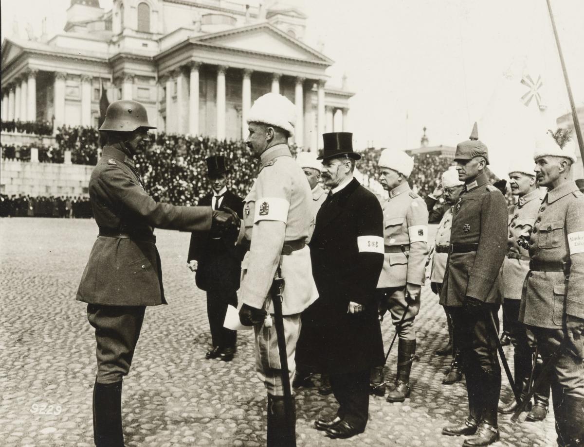 Valkoiseen pukeutunut Mannerheim kättelee saksalaista upseeria Senaatintorilla